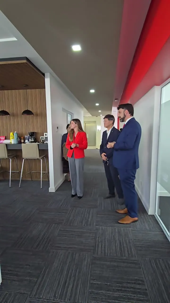 Participantes reunidos en una sala, fotograma del video