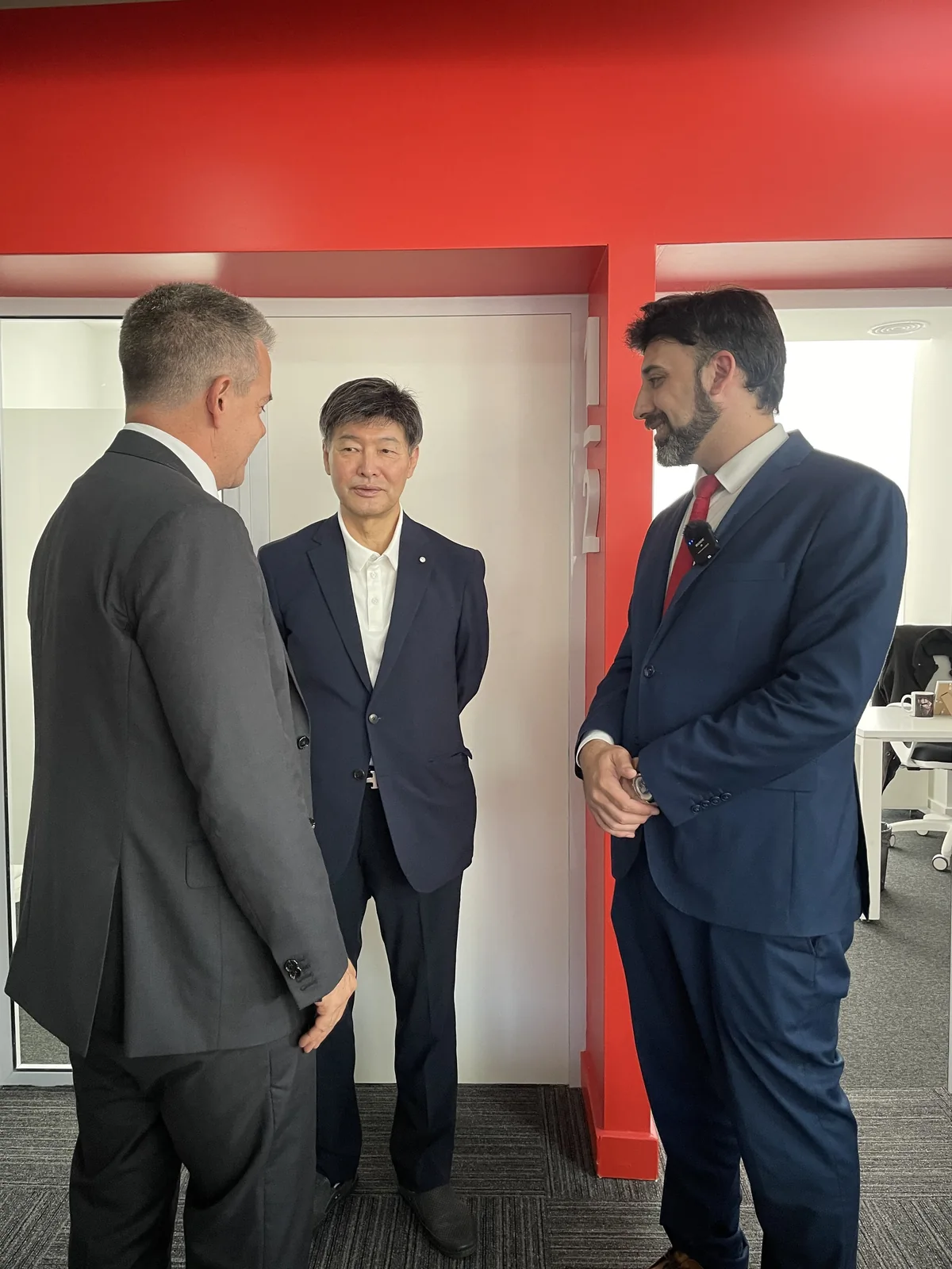 三位参与者在一次机构访问期间于办公室交谈